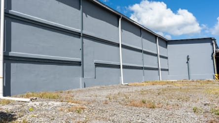 Large grey warehouse wall with open yard Plazas Mas Commercial Center Bugaba Panama