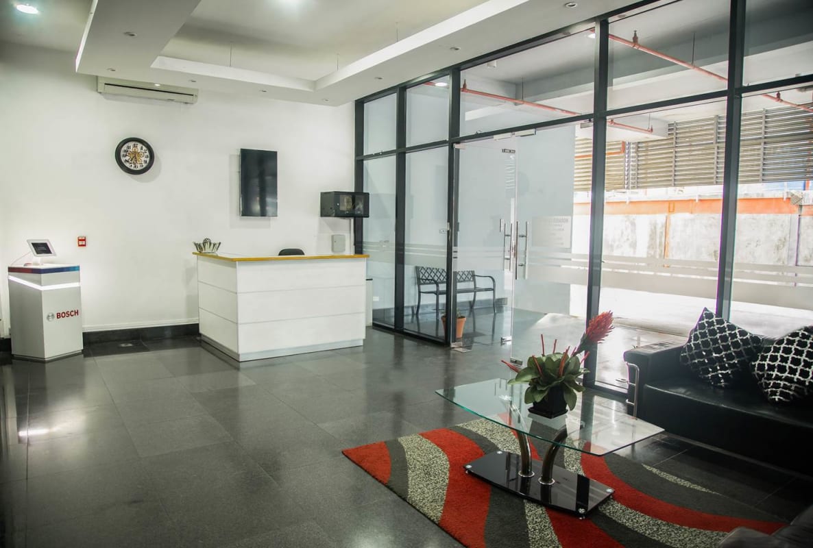Glass-walled reception with modern decor, leather sofas, and bright welcome area at Paitilla Office Tower Panama