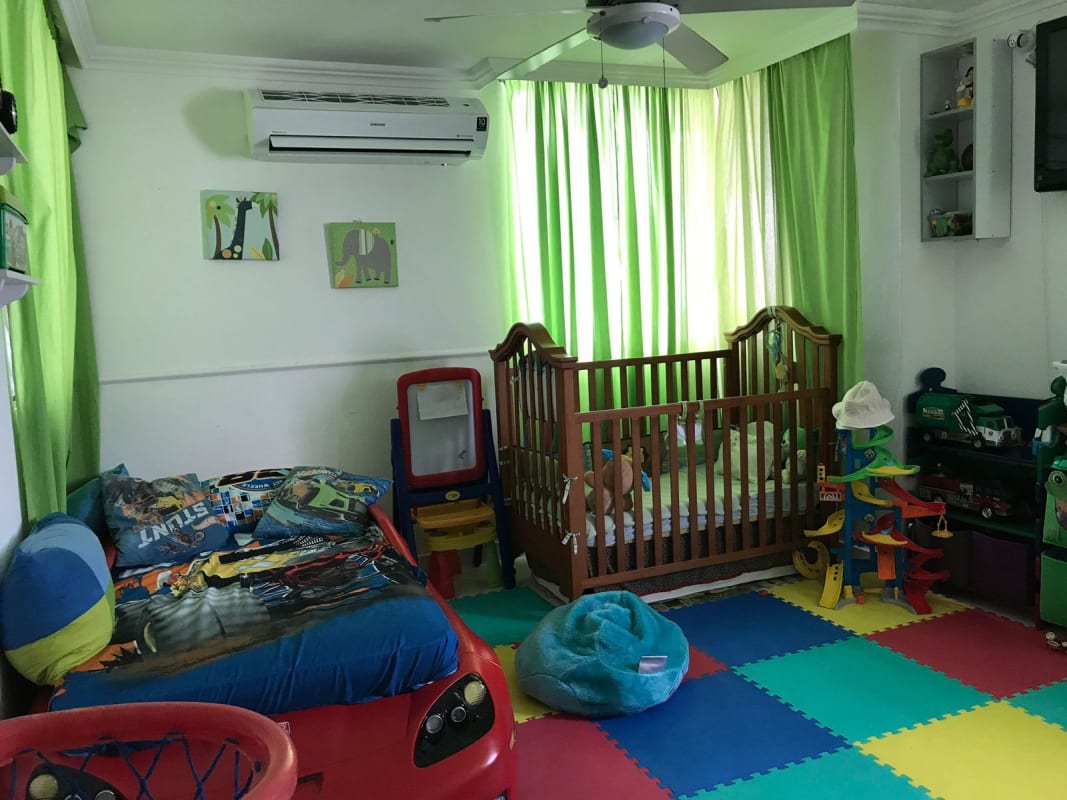 Colorful child’s bedroom with crib, car bed, toys and AC at PH El Carmen Vista Hermosa Panama City