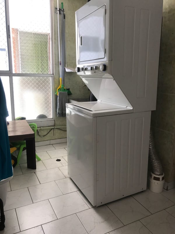 Laundry space with stacked washer dryer and storage at PH El Carmen Panama City Panama