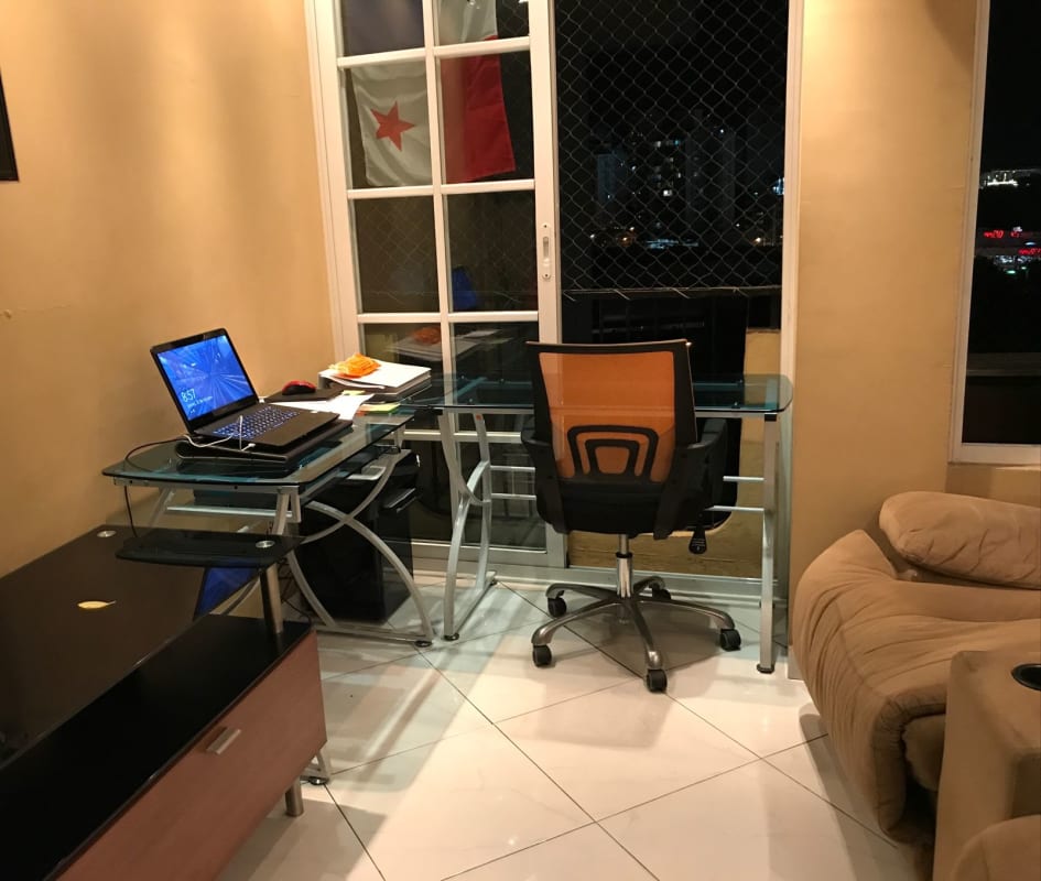Bright home office area with balcony view, glass desk, and tile flooring in PH El Carmen Vista Hermosa