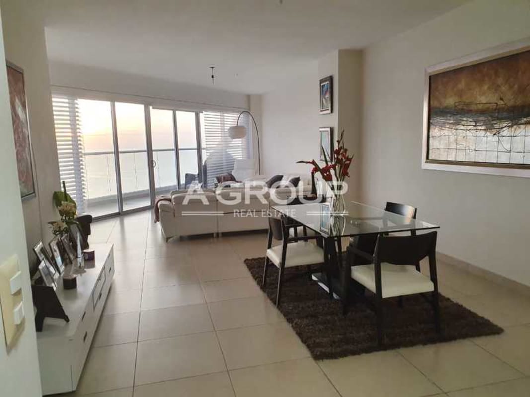 Dining space facing balcony and ocean in high-rise apartment PH Rivage Panama