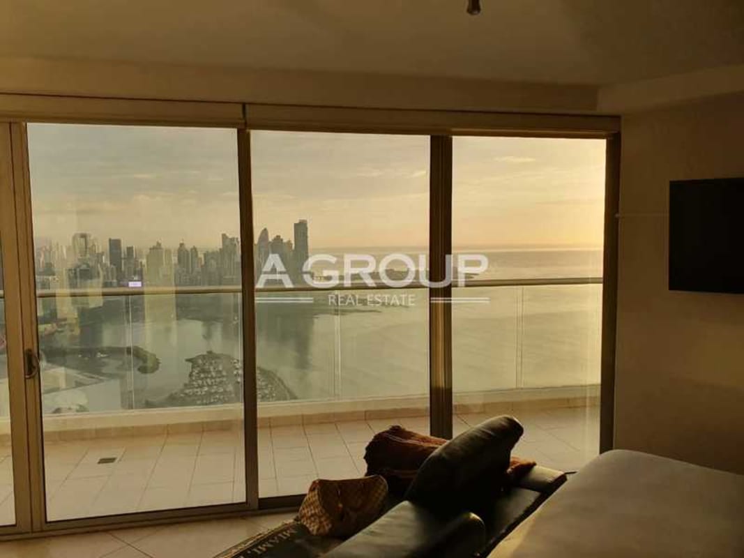 Modern living room with panoramic floor-to-ceiling windows overlooking Pacific Ocean in PH Rivage Tower Panama