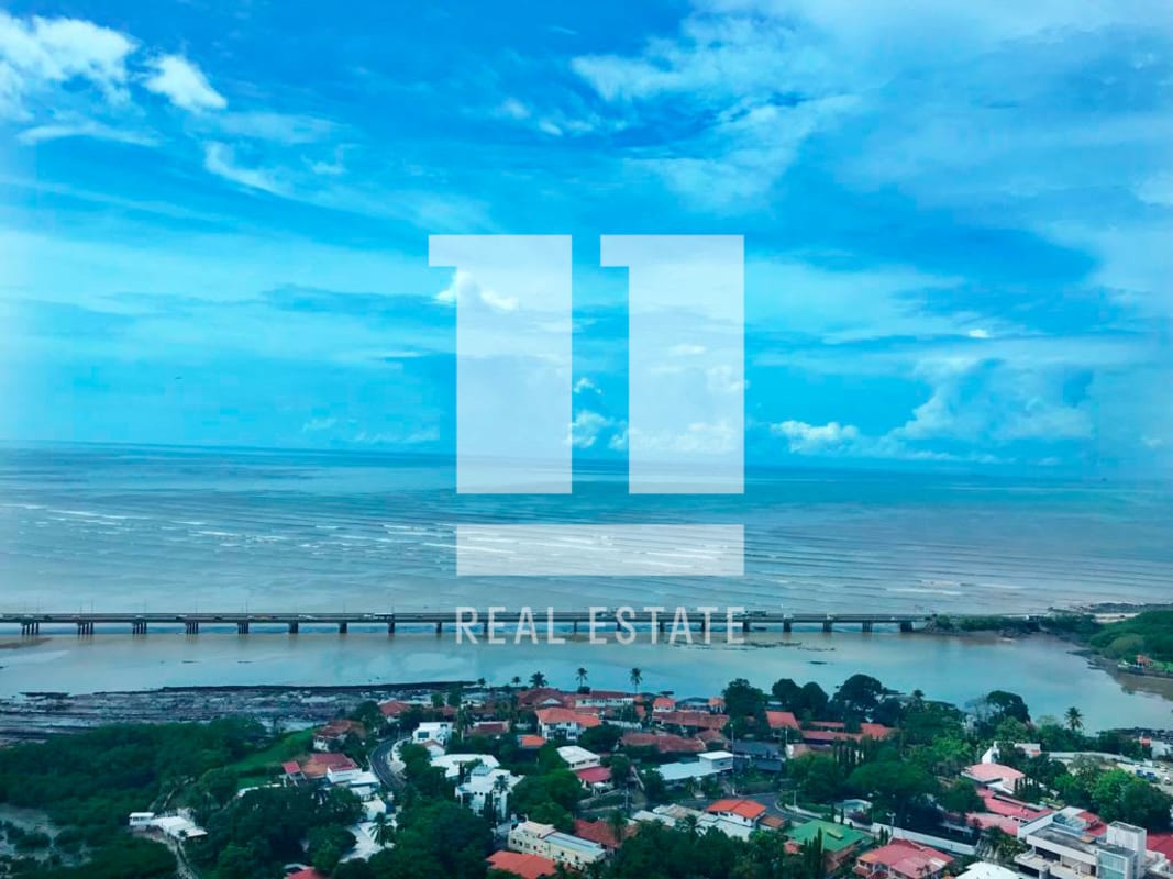 Modern kitchen with wood cabinetry, stainless appliances, granite counters and ocean view window in PH Puntarenas penthouse Panama City