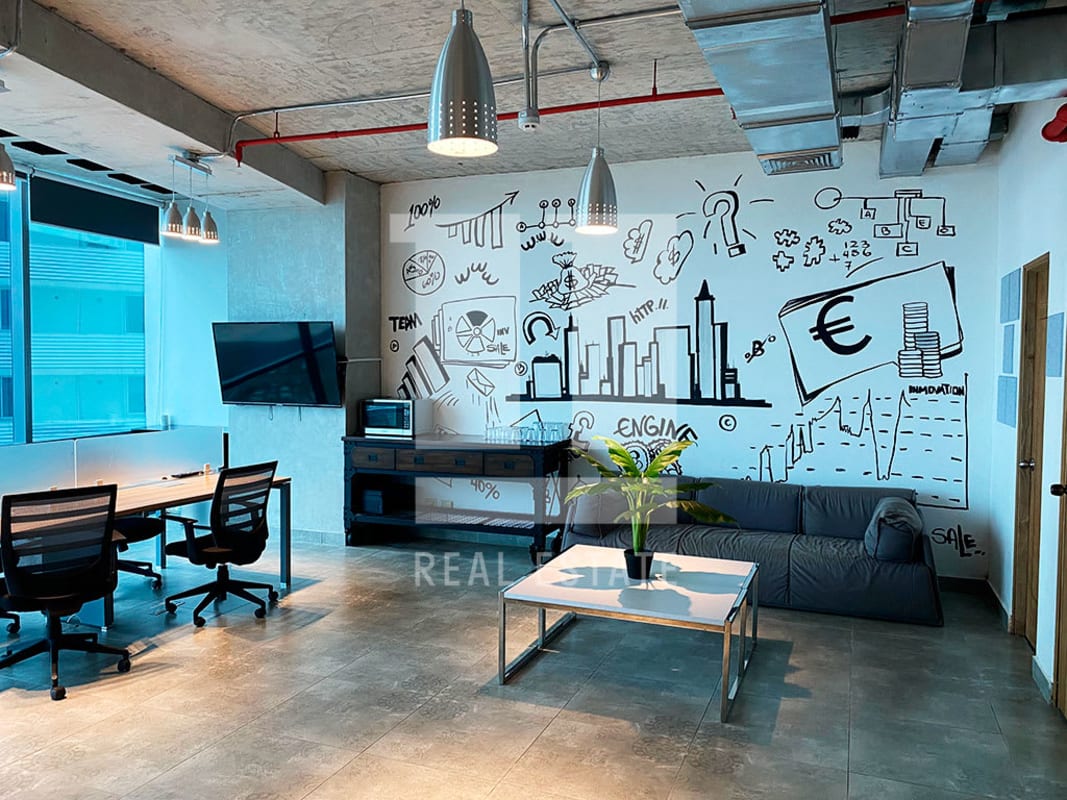 Open workspace with industrial ceiling, pendant lights, desks, bright natural lighting PH Financial Park Costa del Este