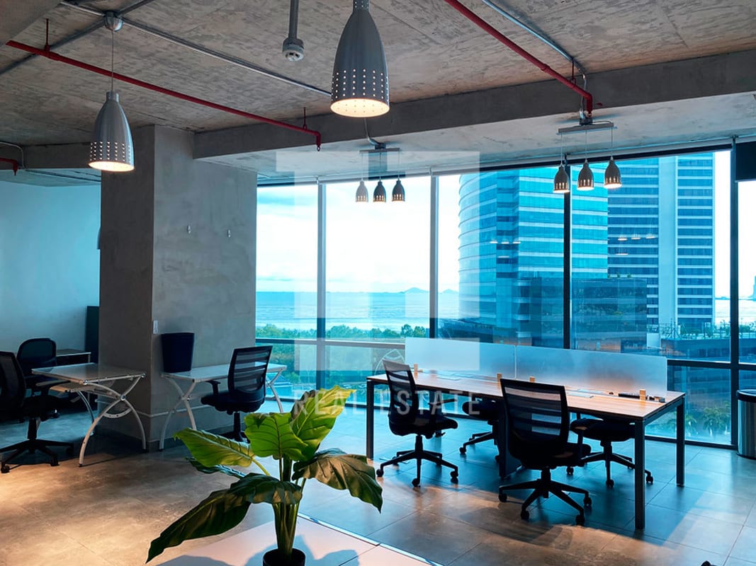 Open-plan office with large windows, industrial loft design, overlooking ocean at PH Financial Park Costa del Este