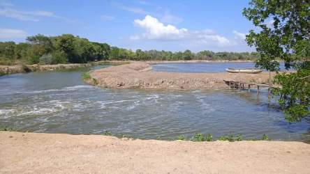 Serene riverbank with boat and sandbanks aquaculture land Aguadulce