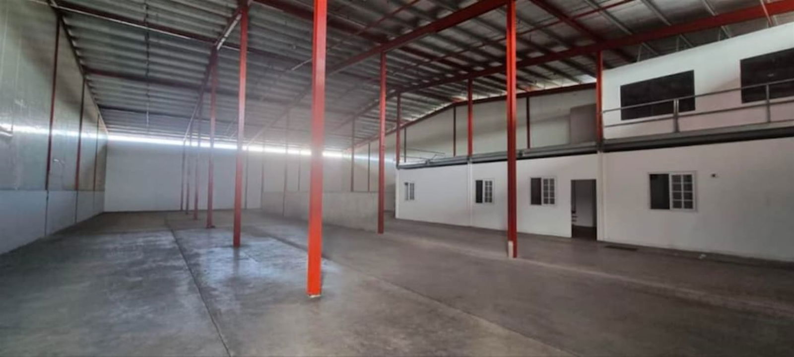 Open industrial warehouse with red beams and mezzanine office in PH Tocumen Logistic Center Panama