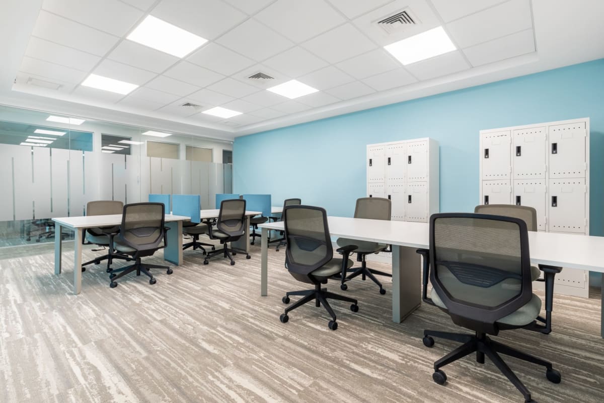 Open plan coworking area with blue accent wall frosted glass partitions and lockers Banistmo Tower in Panama City