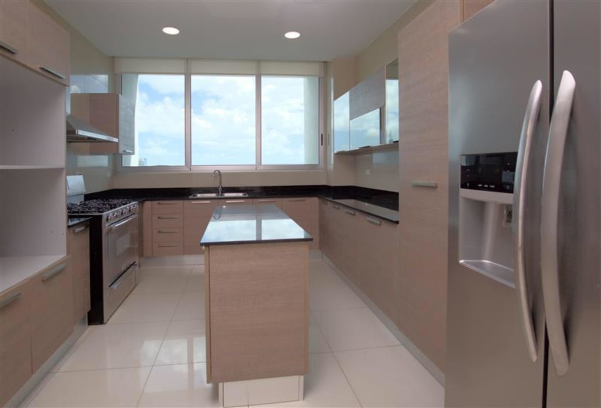 Kitchen with large windows, granite counters, island, stainless appliances in PH Aventura Punta Paitilla