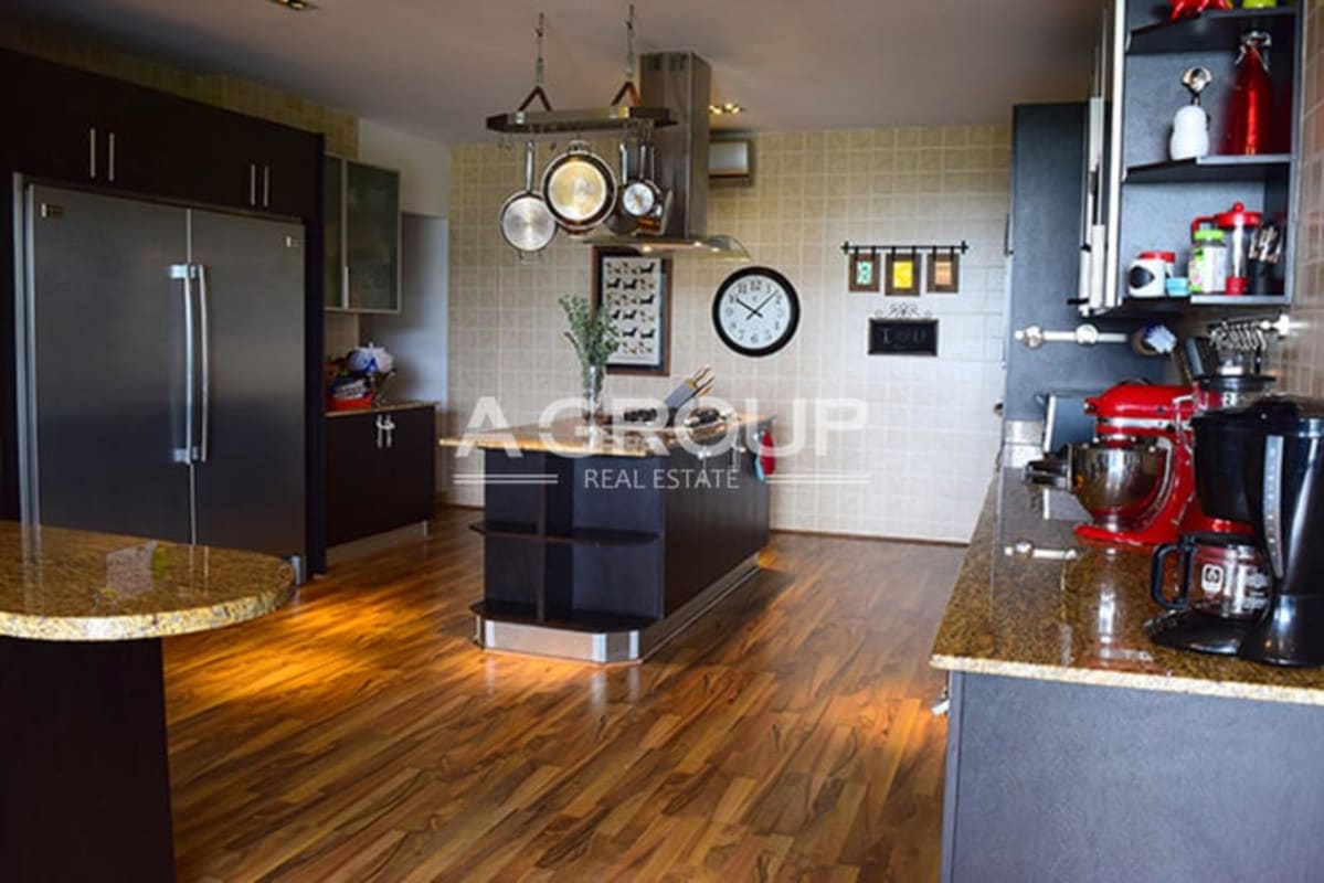 Spacious kitchen with granite countertops, island, wooden floors in luxury Amador Heights apartment Panama