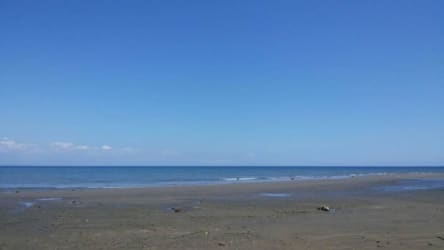 View of calm Pacific beach with blue sky and ocean at Puerto Armuelles Chiriqui Panama
