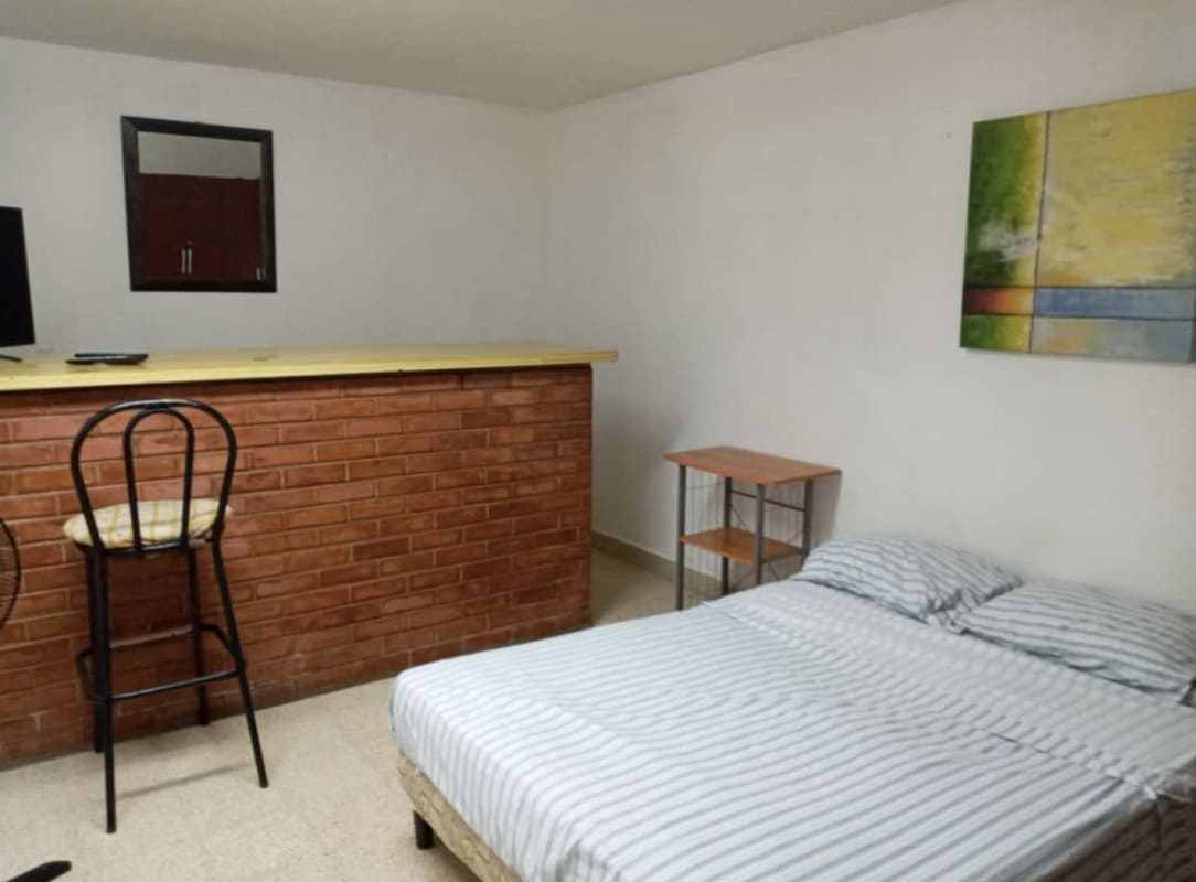 Studio apartment interior with brick bar, bed, TV in Villa de las Fuentes Dorado Panama