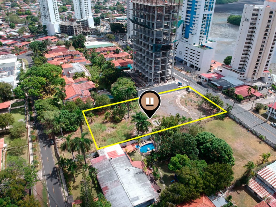 Aerial of cityscape with residential towers and vacant land near ocean Panama City