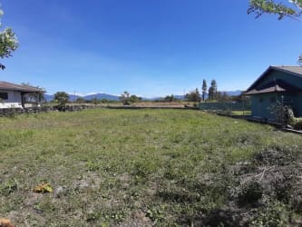 Open grassy plot of land with a small nearby house and mountain views Urbanization Nuevo David Boquete Panama