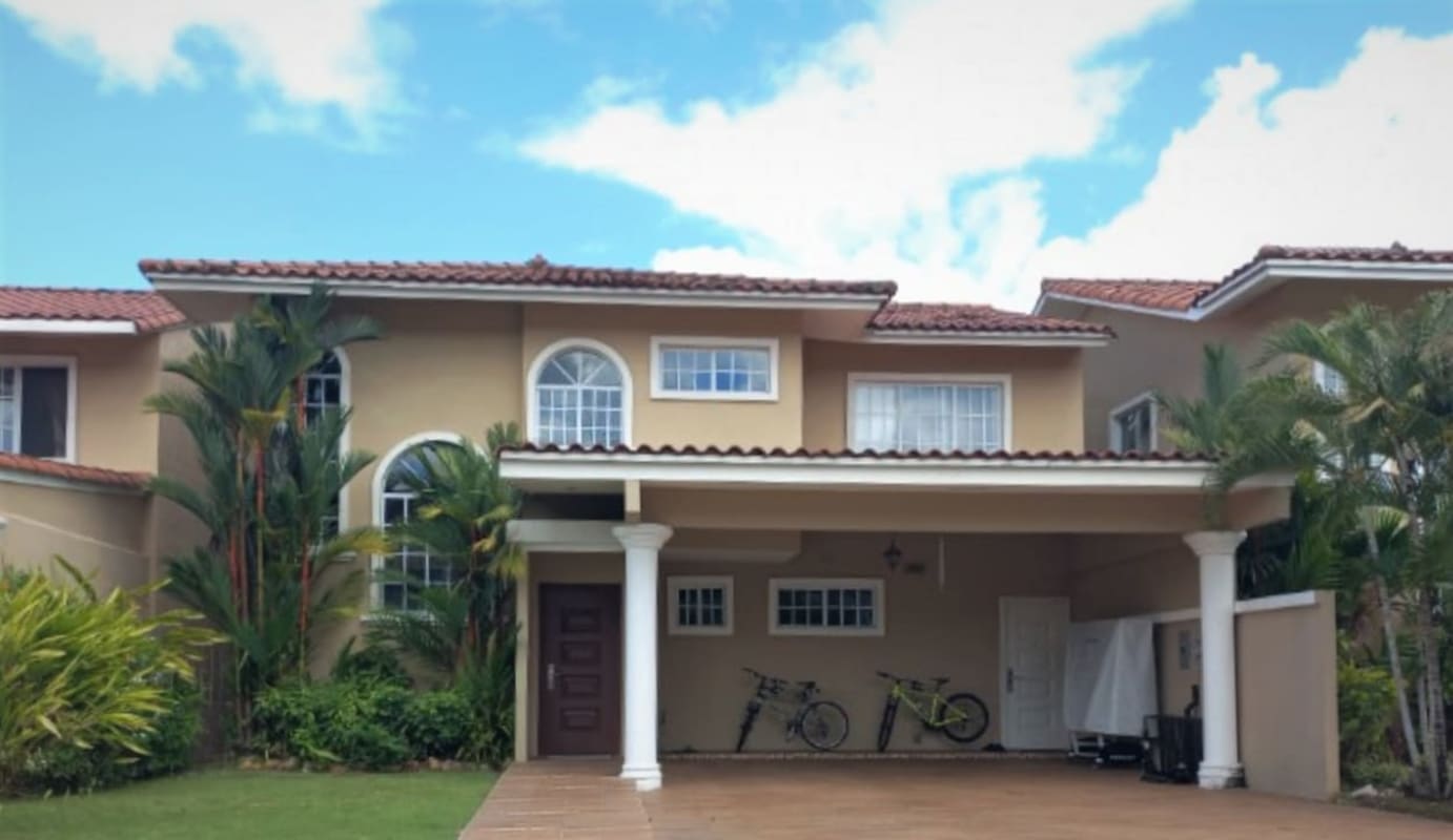 Two-story house with arched windows tile roof columns landscaped garden Castel Novo Panama