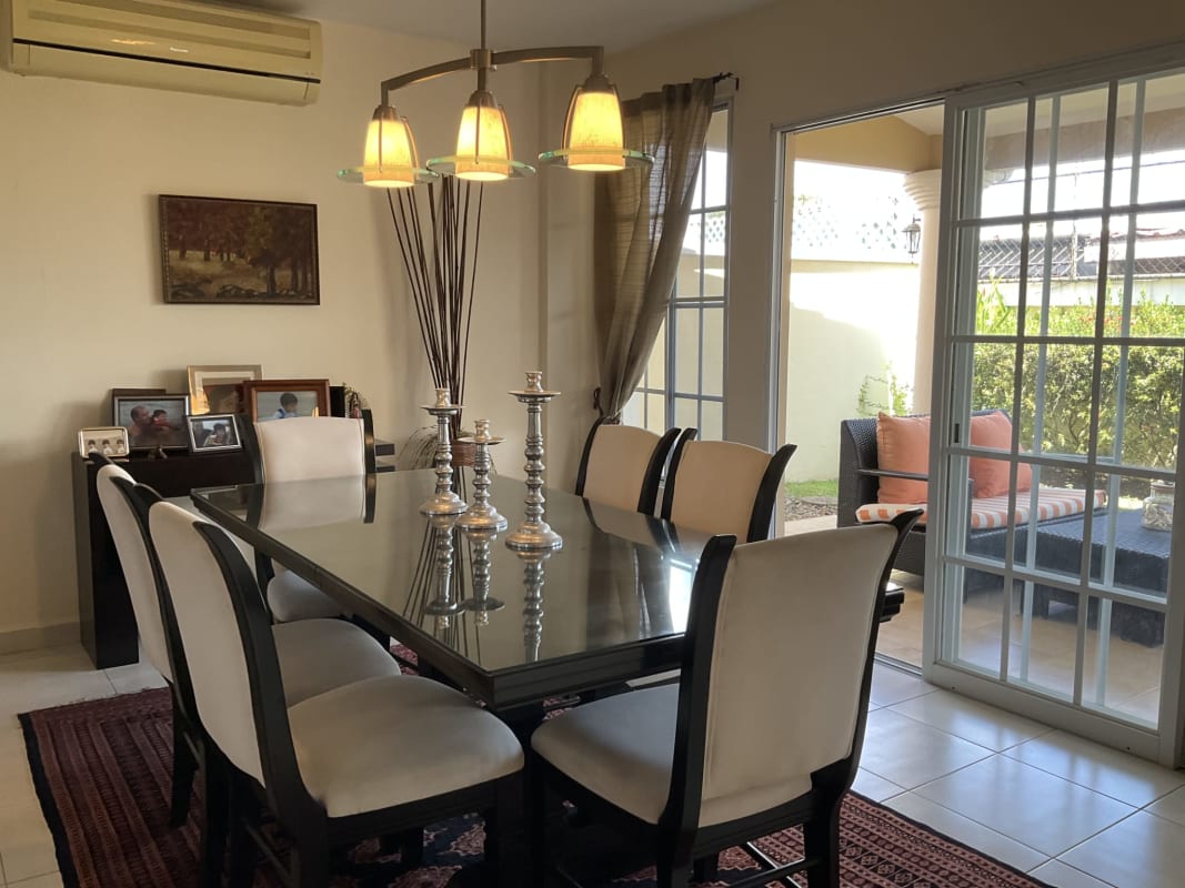 Glass dining table with sliding doors to patio at Castel Novo house in Panama City