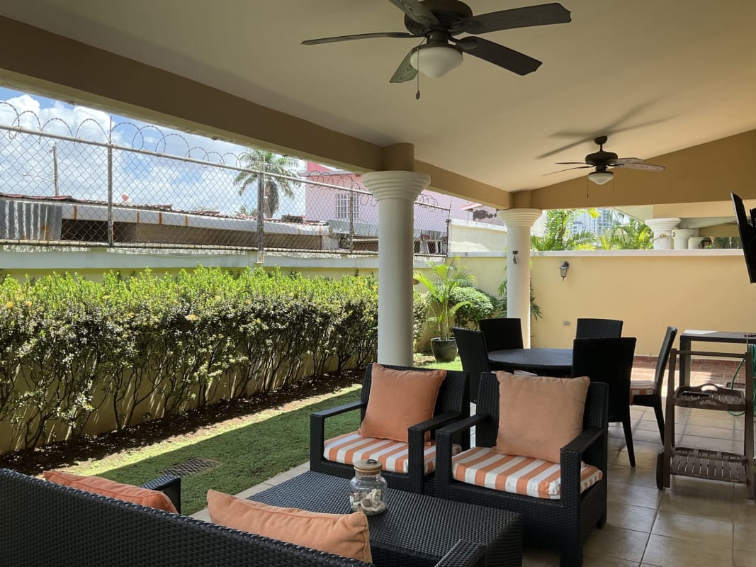 Outdoor terrace with ceiling fans, garden view, striped cushions Castel Novo Panama City home