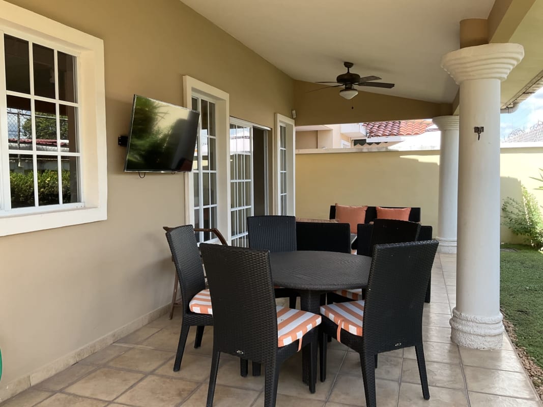 Covered garden terrace with TV lounge outdoor dining set Castel Novo house Panama