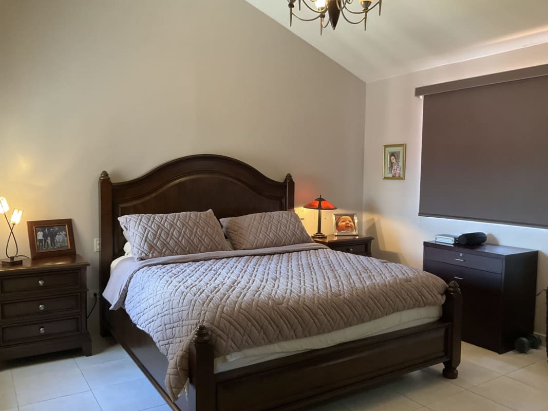 Traditional bedroom beige walls wooden bed chandelier tile floor Castel Novo home Panama
