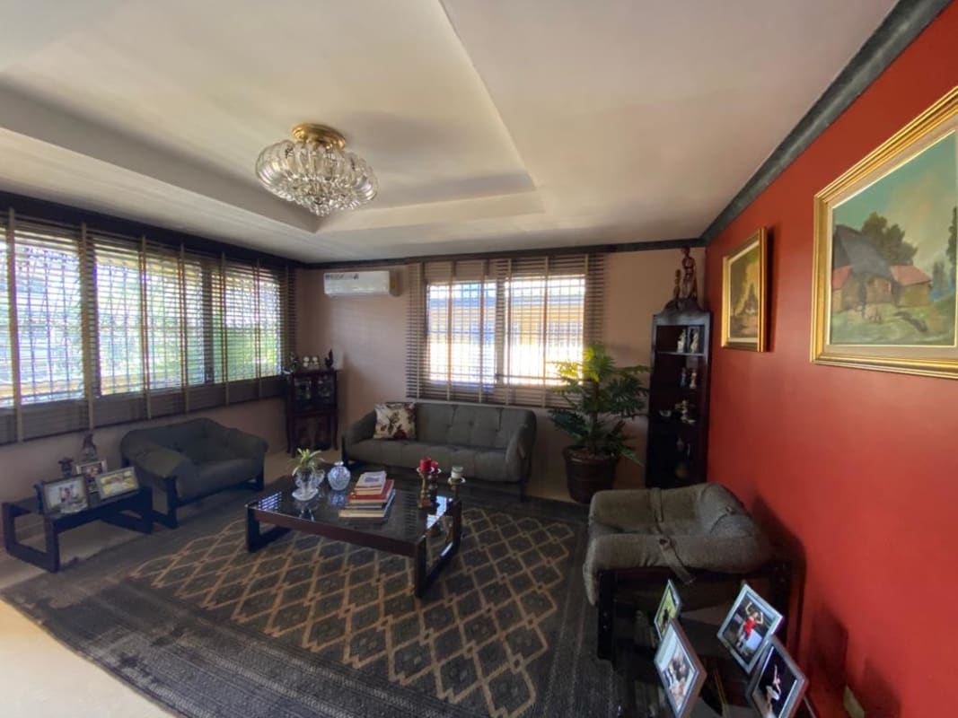 Spacious living room with large windows, chandelier and traditional decor in Bethania Panama house