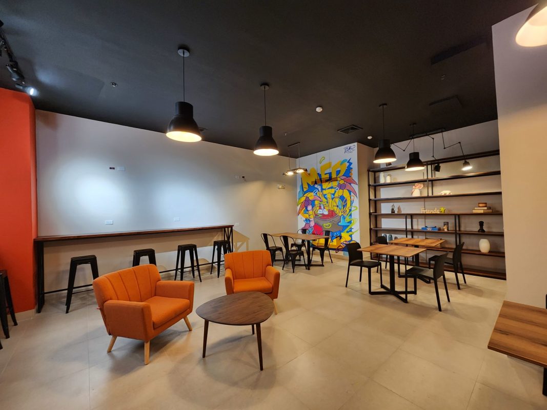 Lounge with colorful mural and mixed seating inside Mercato Food Court Torre Banesco