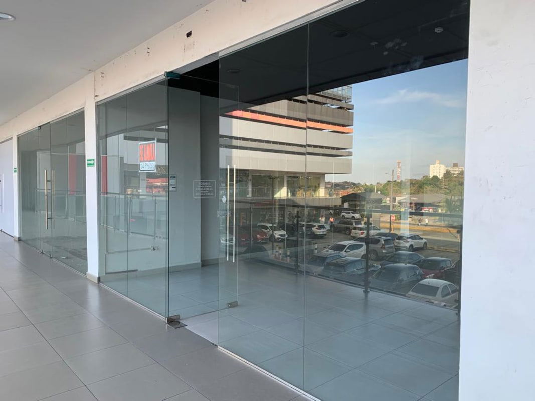 Shopping corridor with multiple glass storefronts interior PH Centennial Center in Panama City