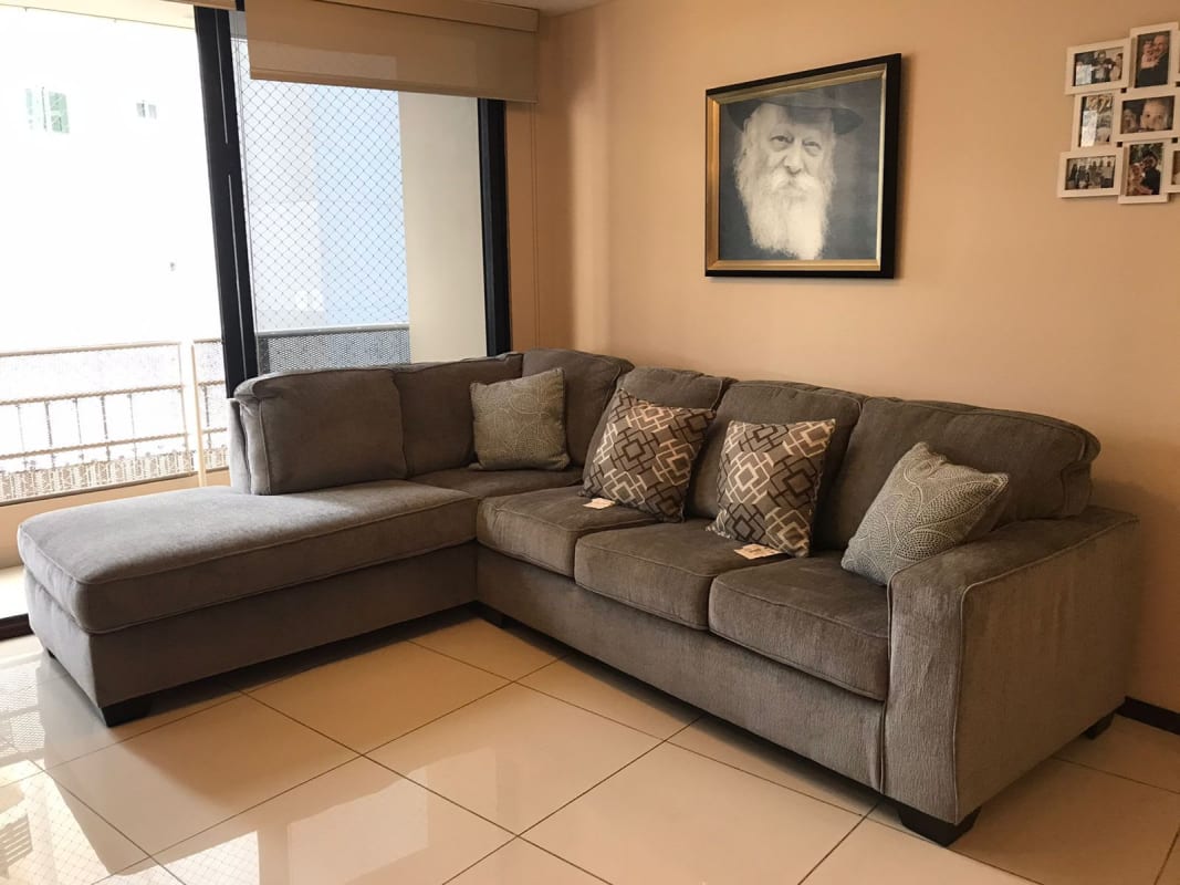 Living room with sectional sofa, large windows, and artwork PH Royal Princess Panama
