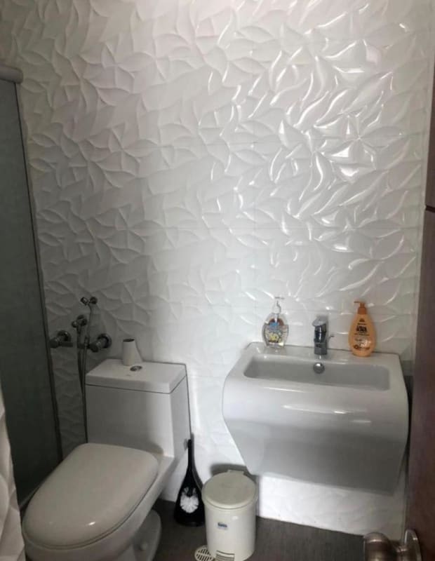Modern bathroom with shower, white fixtures and tile at PH San Francisco furnished apartment Panama