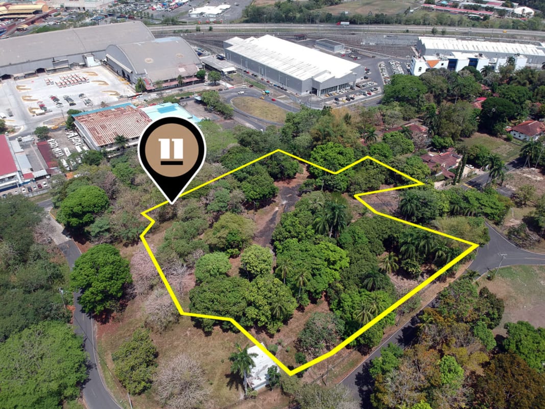 Aerial outlined Panama City development lot with mature trees adjacent commercial center