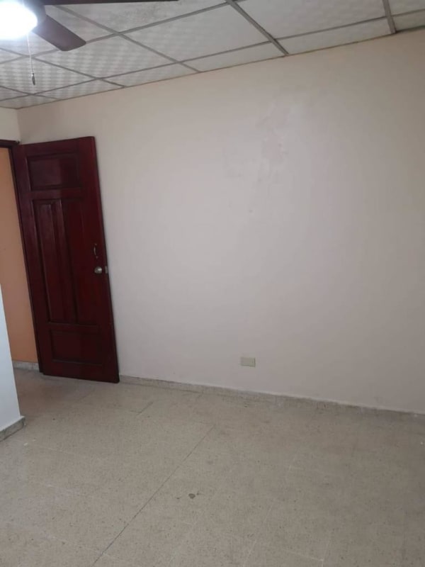 Empty bedroom with ceiling fan, tile floor, wooden door in Cerro Lindo Condado del Rey Panama