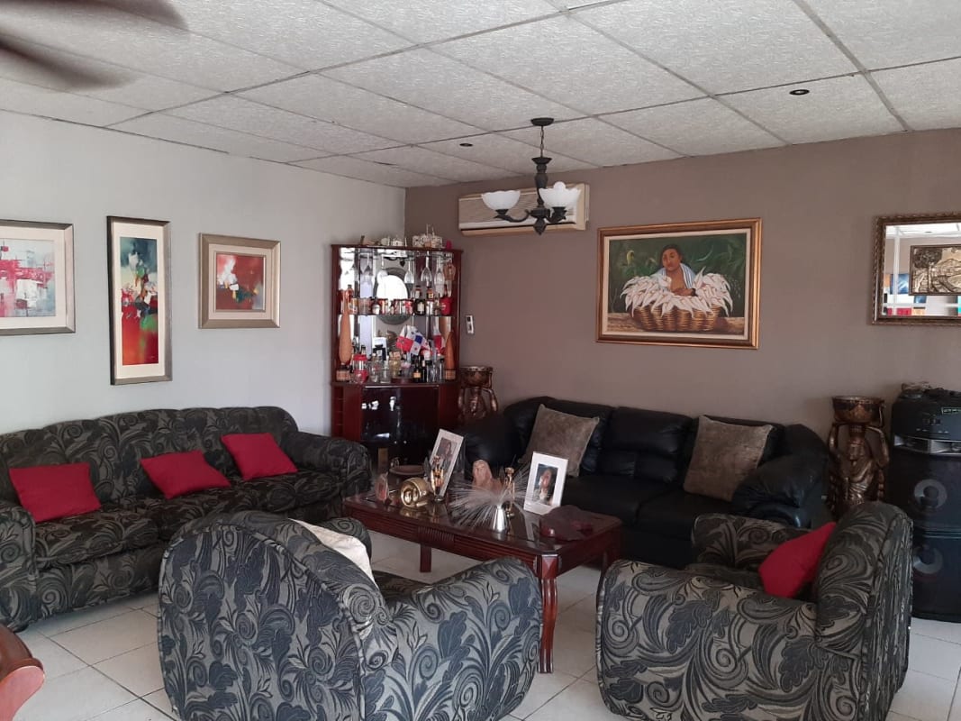 Living room with ornate ceiling, couches, wall art, tile floors, air conditioning in Panama