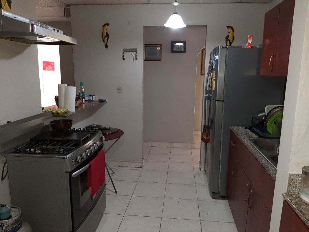Kitchen with granite counters, stainless stove, range hood, refrigerator in Praderas del Rocio Panama