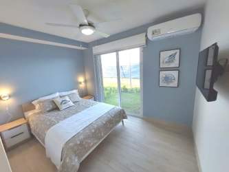 Primary bedroom with large windows, ocean pool views, AC and closet in Punta Chame condo for sale