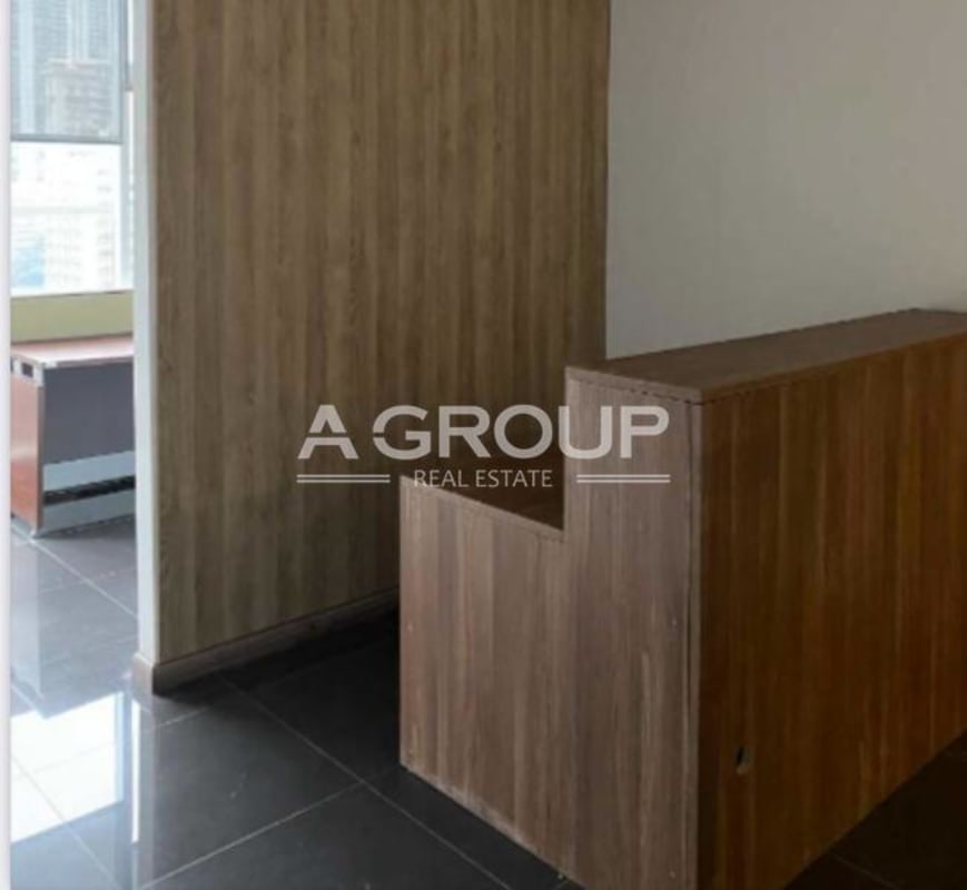 Reception desk with wood panel walls, dark flooring and natural light at PH Habitats Plaza