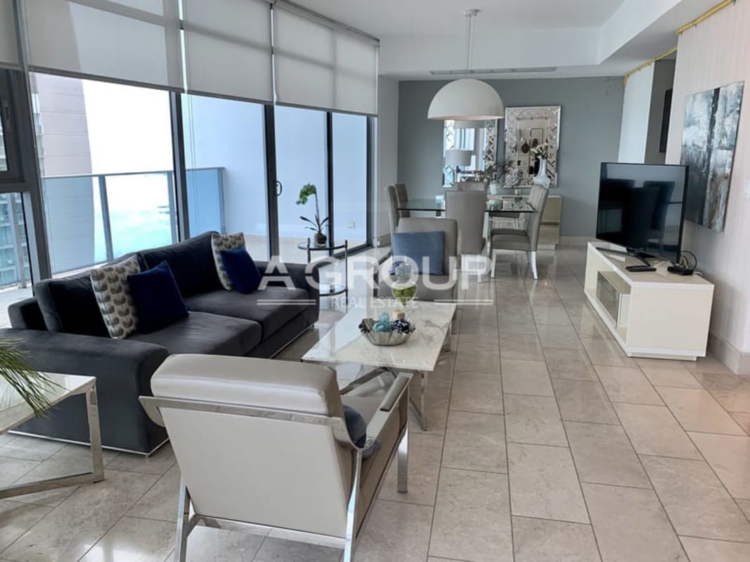 Contemporary dining space with glass windows overlooking ocean PH Grand Tower Punta Pacifica