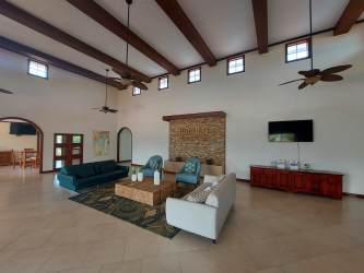 Spacious rustic contemporary living room with beams fireplace and bright light community clubhouse