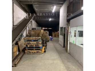 Large industrial warehouse interior with concrete floors, metal staircase, and pallet storage at Zona Libre Colon Panama