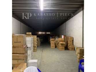 Storage zone inside commercial warehouse with stacked boxes under metal roof in Colon Zona Libre Panama
