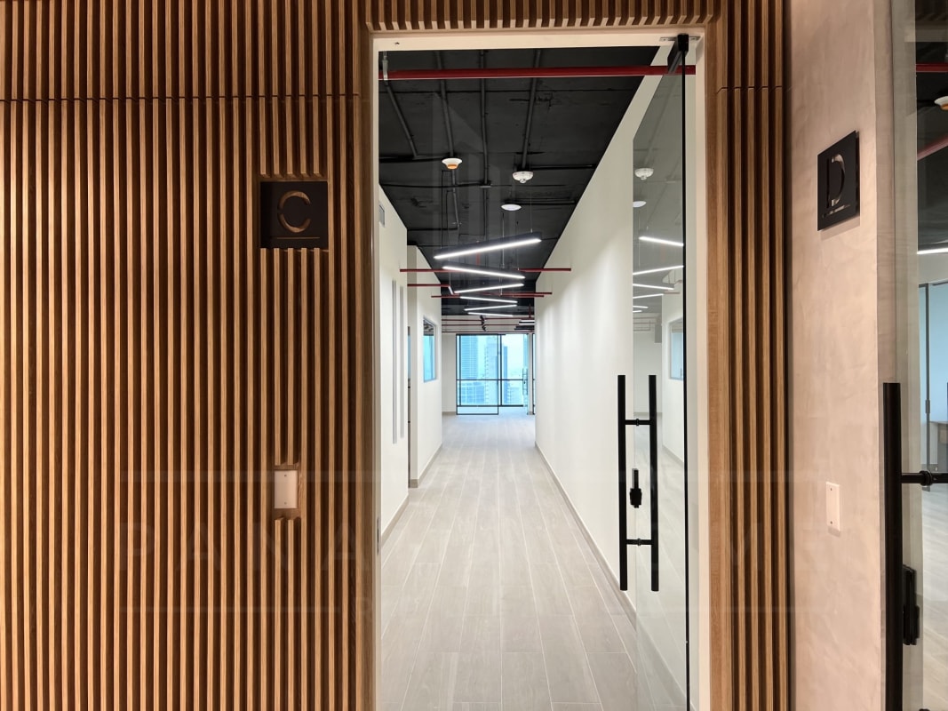 Furnished kitchenette in office with wood cabinetry and glass partition walls in Tower Bank Panama