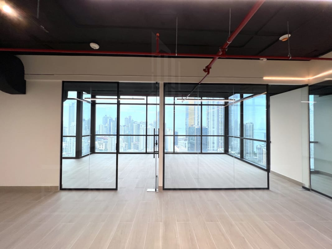Open-plan office area with floor-to-ceiling windows overlooking Panama City Financial District