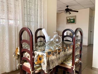 Dining room with sunflower tablecloth, wooden table, ceiling fan in affordable house David Panama