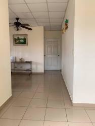 Bathroom with tiled walls, frosted glass shower enclosure, toilet and ceramic finishes in affordable house David Panama