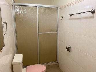 Bedroom with white wardrobe, ceiling fan, tiled floor in affordable family house David Chiriquí Panama