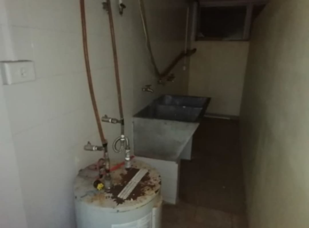 Functional kitchen with MDF cabinets, ceramic backsplash, gas stove and fridge in La Alameda house Panama City