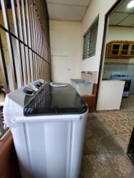 Apartment laundry area with washing machine and sink within Aguadulce rental complex for sale