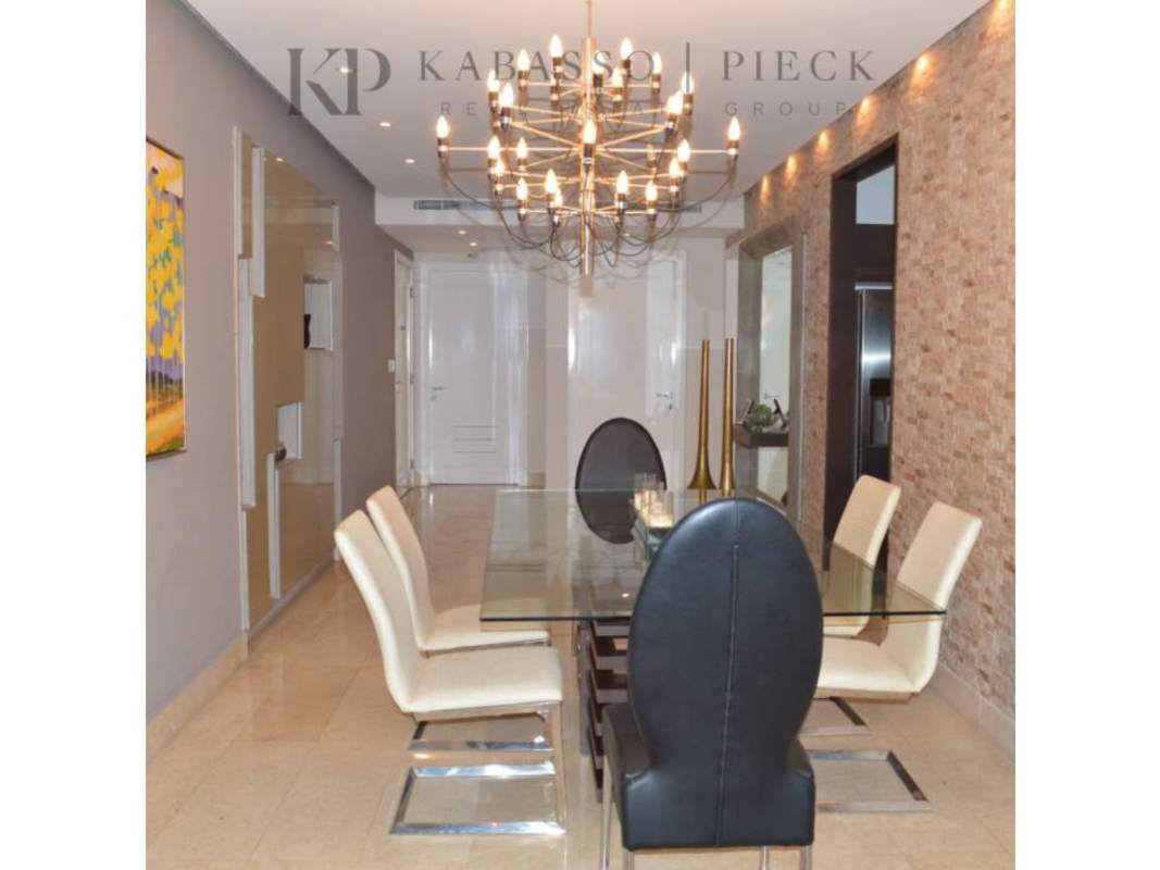 Modern dining room with chandelier, glass table, and open ocean views at YOO & Arts Panama City