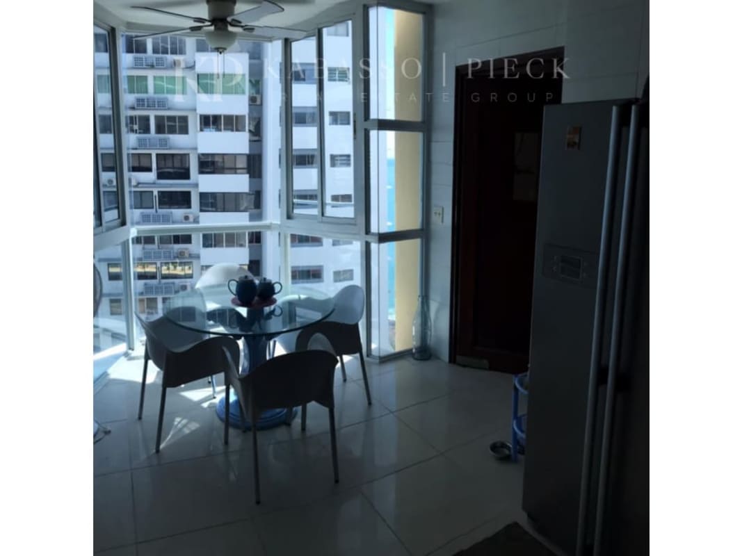 Bright dining space with glass table large corner windows cityscape Panama City