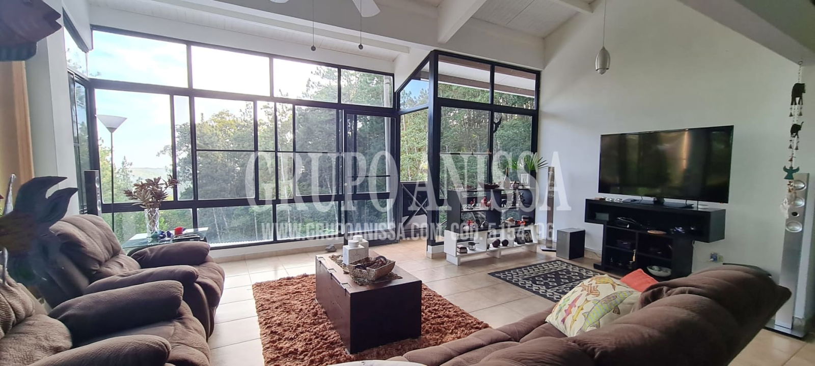 Cozy second bedroom with large windows overlooking lush forest Cerro Azul mountain community