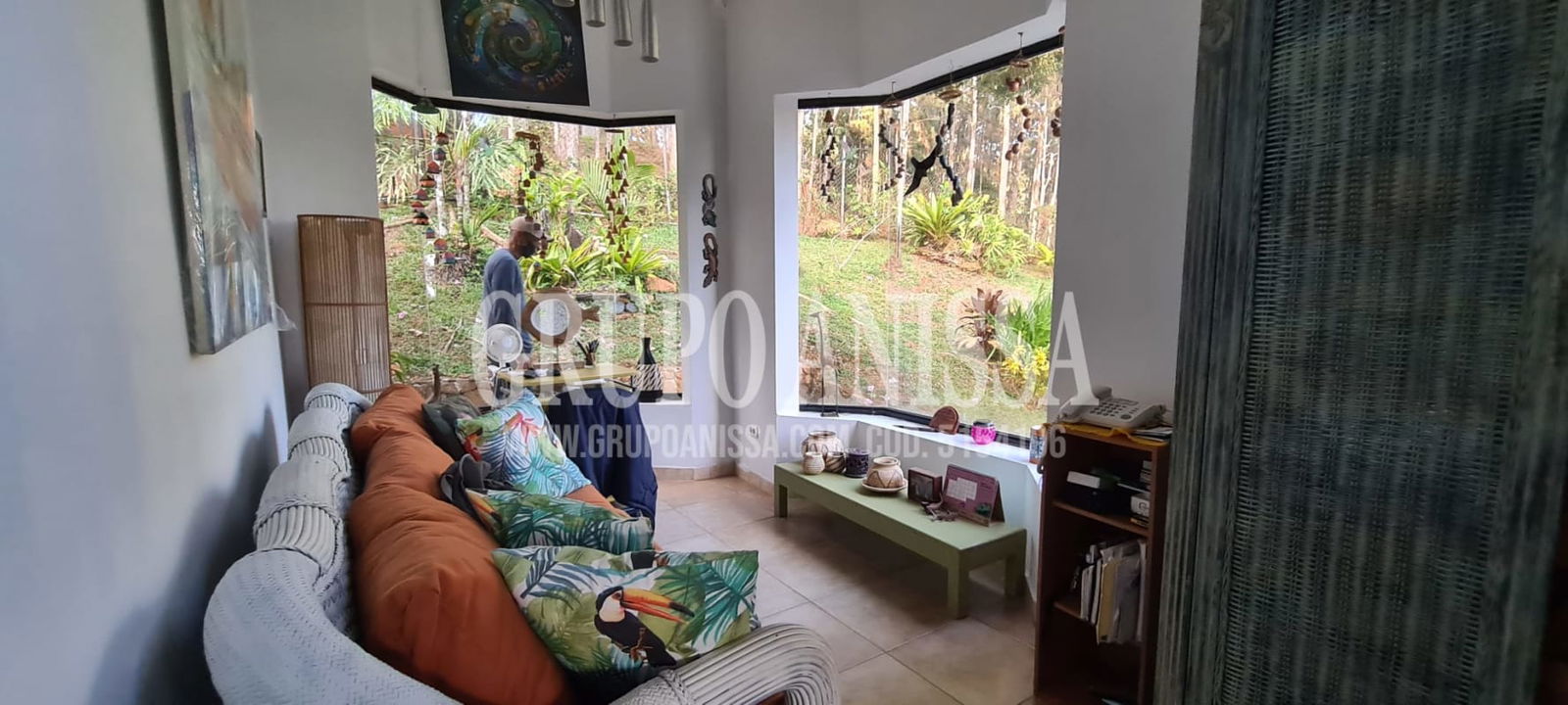 Covered terrace with rustic columns overlooking gardens and tropical forest in Cerro Azul mountain house